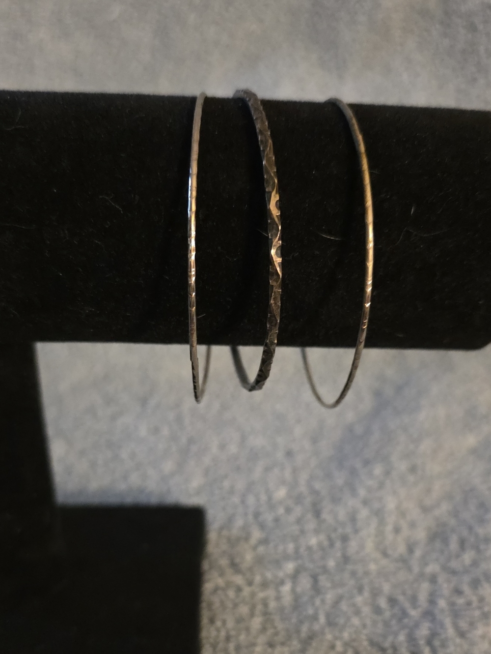set of three thin, silver-toned metal stackable bangle bracelets